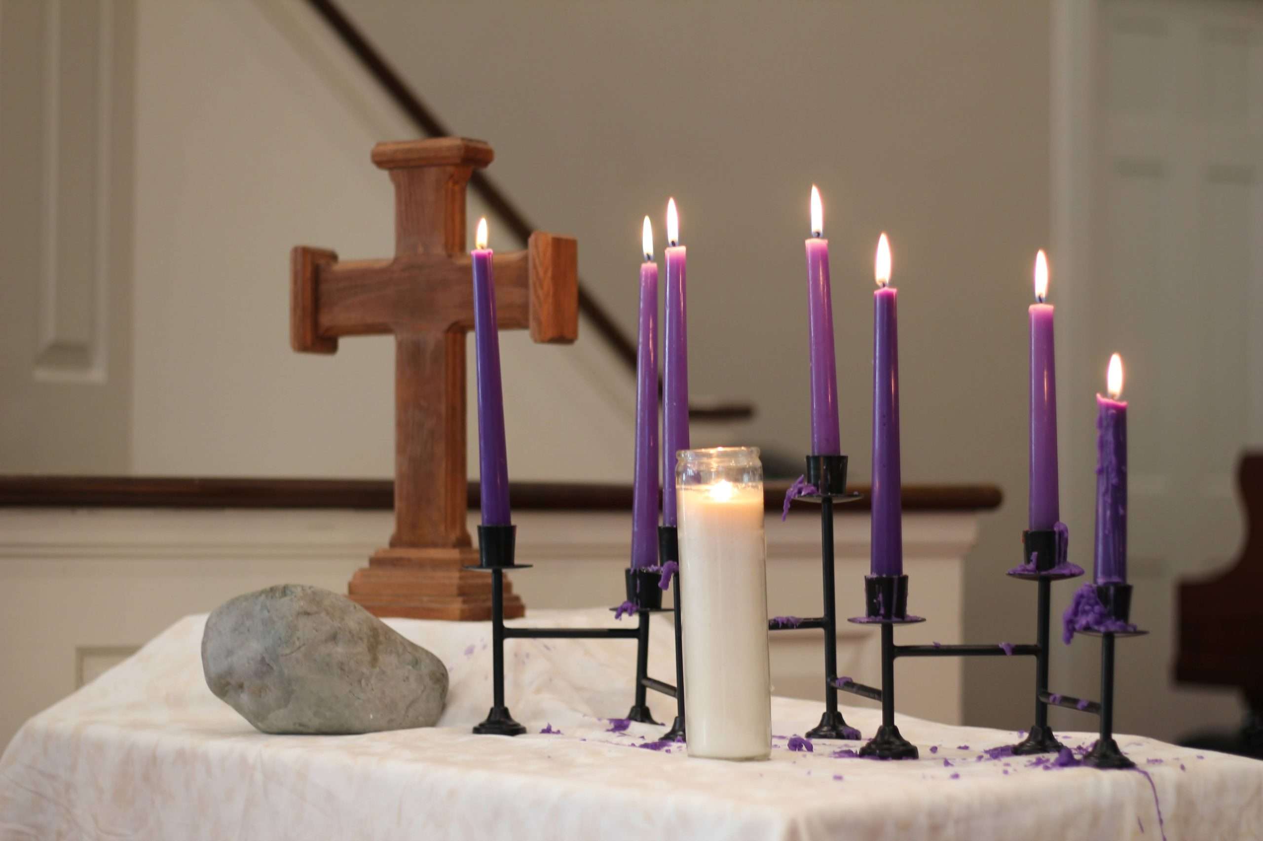A cross and Advent candles on the communion table.