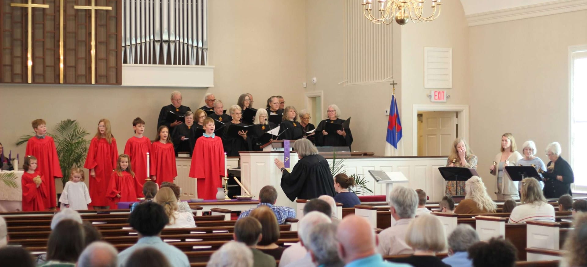 Children's and adult choir members leading worship from the chancel.