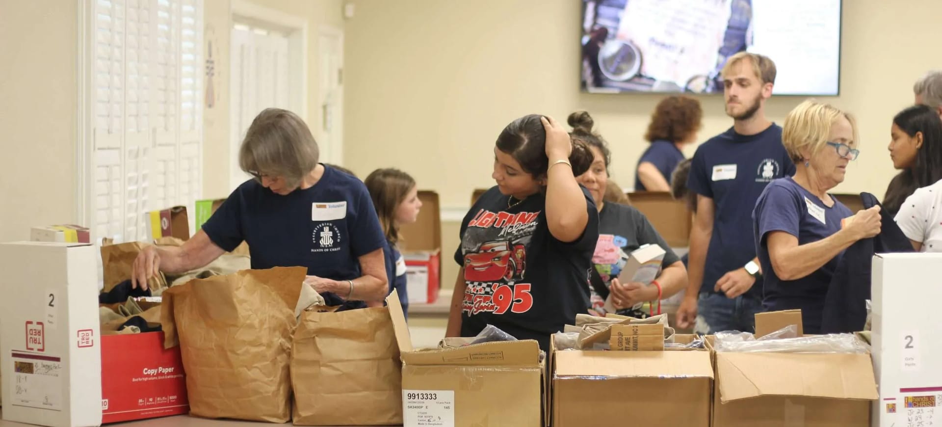 Volunteers sorting donated clothing and supplies for the Hands of Christ ministry.