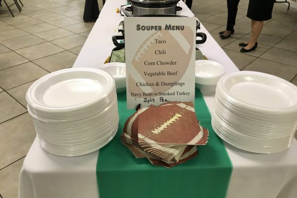 Bowls, napkins, and a hand-written soup menu set out for a fellowship lunch.